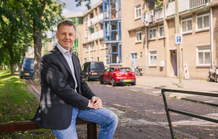 Gijsbert van Herk op hekje voor woningen