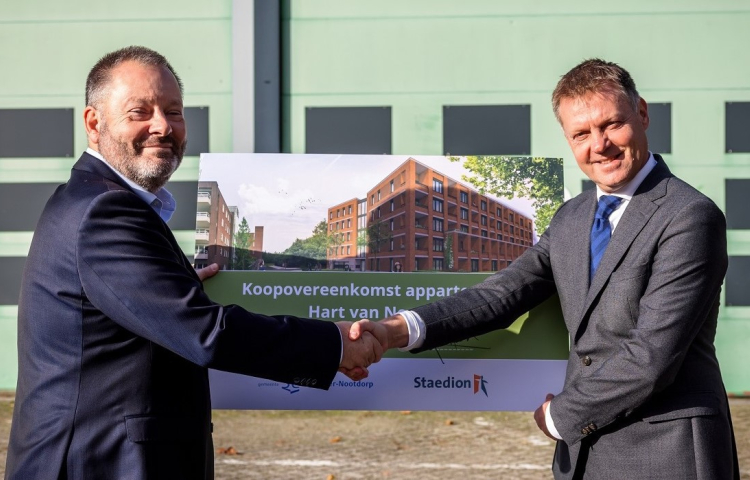 Gijsbert en Wethouder van Kuppeveld schudden hand en houden een bord van het project in hun hand