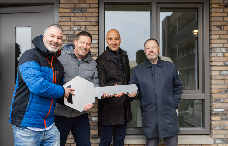 Een uitvergrootte sleutel van het appartementengebouw wordt in ontvangst genomen
