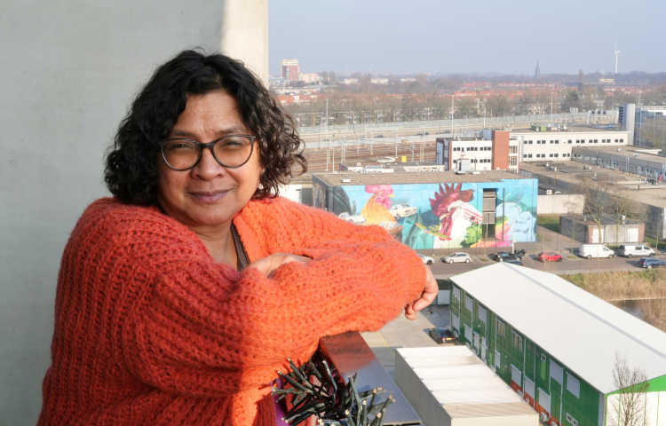 Bewoner Francine leunt over balkonreling